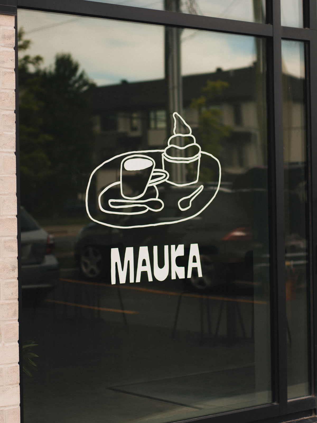 Hand-painted Mauka coffee and ice cream illustration on a café window
